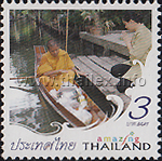 tak baat, i.e. offering food to a Buddhist monk, who is on bintabaat, i.e. alms-begging round, in a reua khem paddle boat